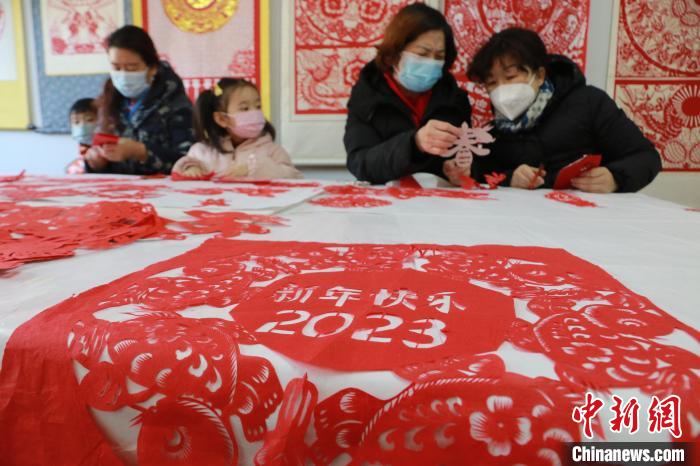 12月30日，在山東省高密市剪紙藝社，非遺傳承人和孩子們正在進(jìn)行迎新年剪紙創(chuàng)作?！±詈?攝