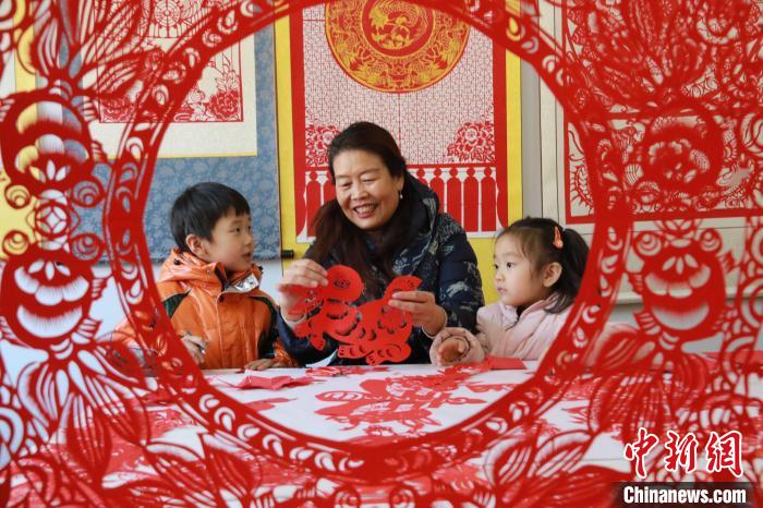 非遺傳承人田桂芹在帶領(lǐng)孩子們進(jìn)行迎新年剪紙創(chuàng)作?！±詈?攝