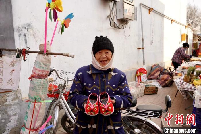 在臨清市康莊鎮(zhèn)黃河大集現(xiàn)場，一位民眾展示手工制作的虎頭鞋?！⒓午?攝