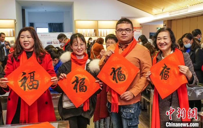 圖為臺(tái)胞在展示寫好的“?！弊帧！∈Y豐慧 攝