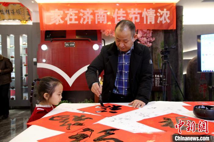 1月13日，山東濟南，書畫家現(xiàn)場潑墨，揮毫書寫福字、春聯(lián)。　孫婷婷 攝