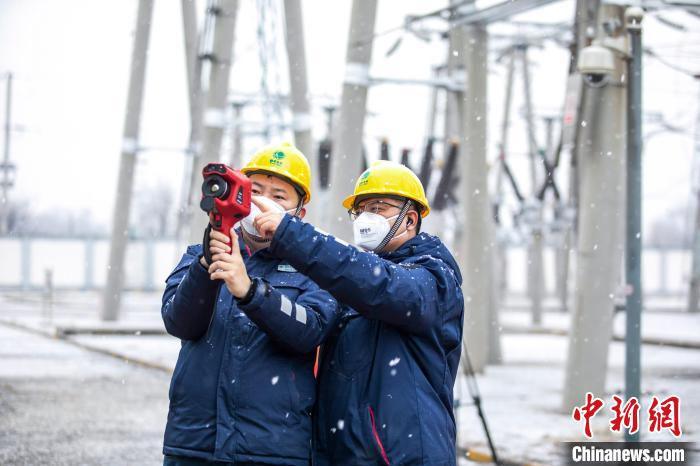 國網(wǎng)北京昌平供電公司運維人員雪天在變電站對站內(nèi)設(shè)備開展巡視測溫?！⑿≤?攝