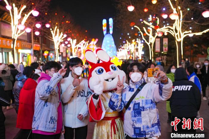 民眾與身著兔子形象的人偶合影?！∥淇〗?攝