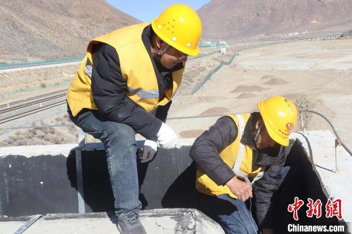 圖為馬智文(左)指導(dǎo)職工進行站房屋頂排水孔的清理作業(yè)。　 馬生明 攝