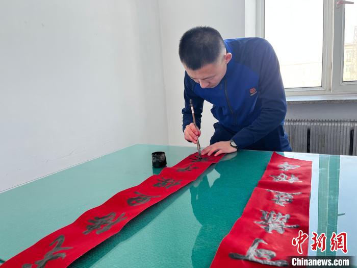 圖為森林消防指戰(zhàn)員自己動手寫春聯(lián)?！∶缱?攝