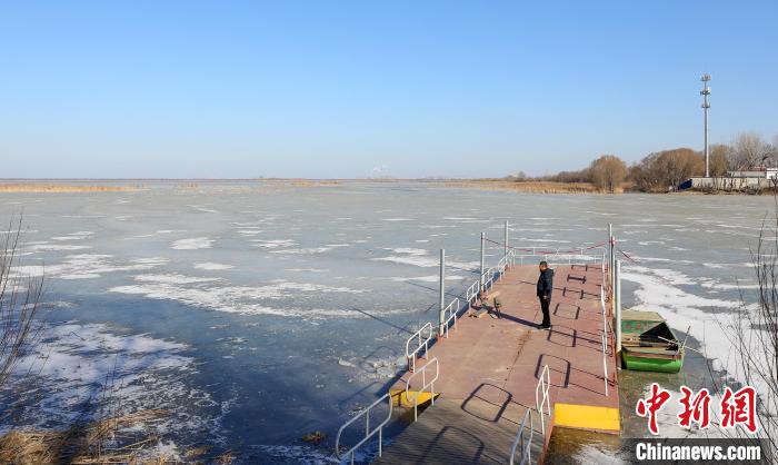 春節(jié)期間，李國忠在碼頭上觀察湖面?！￡惪?攝