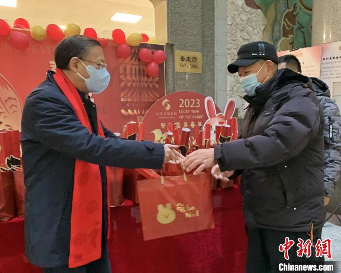 大年初一，山東省圖書館副館長(zhǎng)李西寧帶領(lǐng)工作人員向兔年第一批讀者贈(zèng)送書香大禮包。　吳建彬 攝