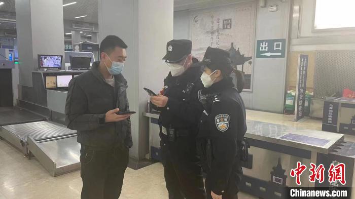 民警劉學(xué)強(qiáng)和李晨俊正在與旅客進(jìn)行交流?！±钚∨?攝