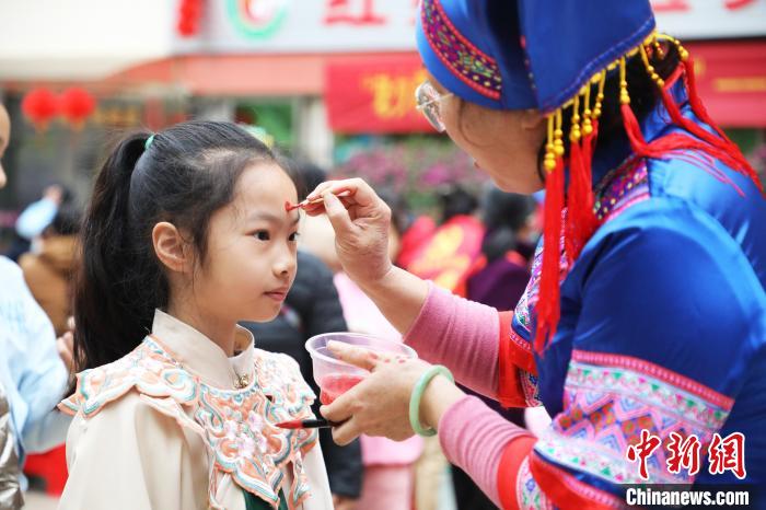 志愿者為小朋友點朱砂痣?！↑S曉君 攝