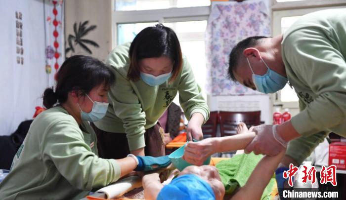 張慧和同事一起為老人進(jìn)行助浴服務(wù)?！∈茉L者供圖