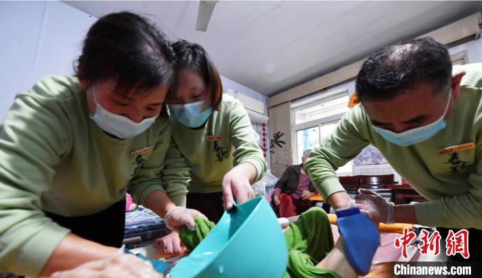 張慧和同事一起為老人進(jìn)行助浴服務(wù)?！∈茉L者供圖