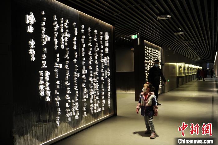 圖為孩童觀賞墻壁上的文字?！「咪?攝