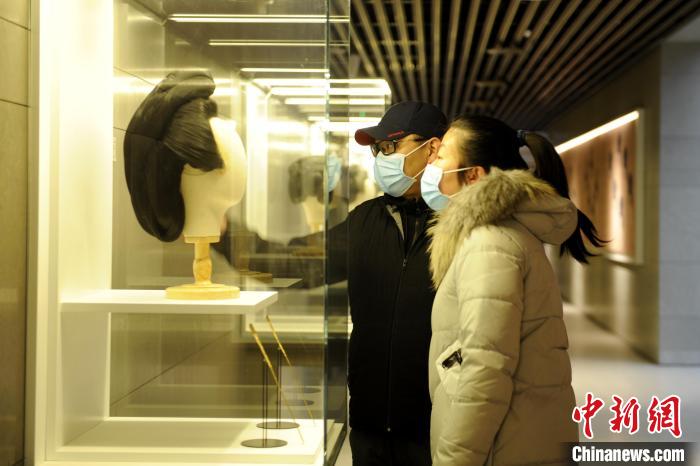 圖為市民觀賞古人發(fā)型展品?！「咪?攝