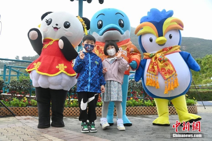 隨著香港與內(nèi)地全面“通關(guān)”，香港不少旅游活動重啟。2月11日上午，香港海洋公園迎來全面復(fù)常后的首個內(nèi)地點(diǎn)對點(diǎn)旅行團(tuán)。該旅行團(tuán)約有140名內(nèi)地旅客由深圳蓮塘口岸乘坐跨境專車直達(dá)香港海洋公園，園方特地為旅行團(tuán)安排歡迎儀式，歡迎他們蒞臨香港海洋公園。圖為兒童與香港海洋公園吉祥物合影。李志華 攝