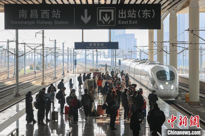 圖為江西南昌西站，一輛列車進(jìn)站，旅客有序在站臺上候車?！⒘?攝