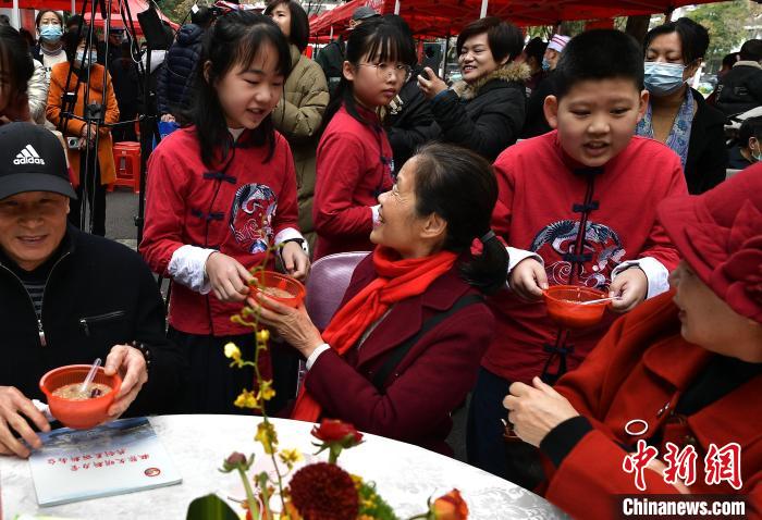 圖為福州市倉山區(qū)第五中心小學(xué)的學(xué)生為參加活動的社區(qū)老人送上拗九粥?！埍?攝