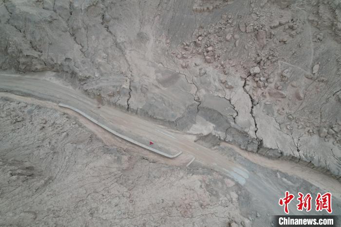 圖為身著紅色工服的熊海林在戈壁深處進(jìn)行巡檢?！≮w凜松 攝