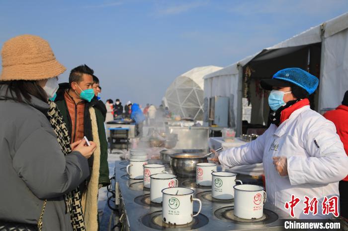 圖為游客在博斯騰湖景區(qū)購(gòu)買“缸子魚”?！『嚏?攝