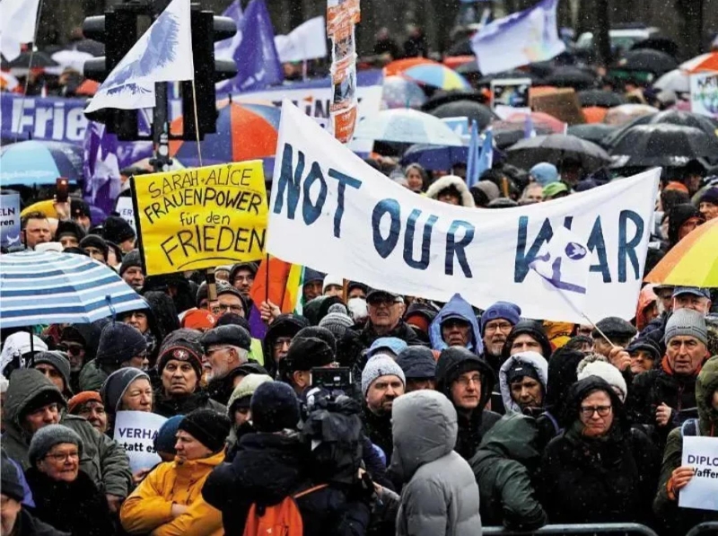 柏林示威者25日高舉“這不是我們的戰(zhàn)爭”標(biāo)語，要求停止對(duì)烏軍援。（大公報(bào)）