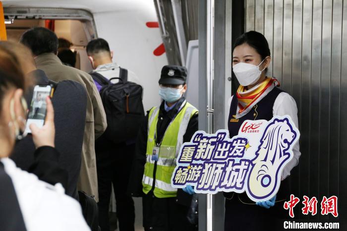 圖為北部灣航空乘務(wù)員在飛機艙門迎接旅客?！↑S秉柱 攝