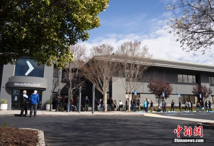 當(dāng)?shù)貢r間3月13日，客戶在美國加州圣克拉拉市硅谷銀行總部門前排隊等候辦理業(yè)務(wù)。美國聯(lián)邦儲備委員會和美國聯(lián)邦存款保險公司(FDIC)12日發(fā)表聯(lián)合聲明，宣布采取行動確保硅谷銀行等存款機構(gòu)儲戶的資金安全。聲明稱，在收到美聯(lián)儲和聯(lián)邦存款保險公司的建議并與美國總統(tǒng)進行協(xié)商后，財政部長耶倫批準(zhǔn)采取行動，使聯(lián)邦存款保險公司能夠以充分保護所有存款人的方式解決硅谷銀行問題。從3月13日起，硅谷銀行儲戶將可以使用所有資金。與硅谷銀行解決問題有關(guān)的任何損失都不由納稅人承擔(dān)。<a target='_blank' href='/'>中新社</a>記者 劉關(guān)關(guān) 攝