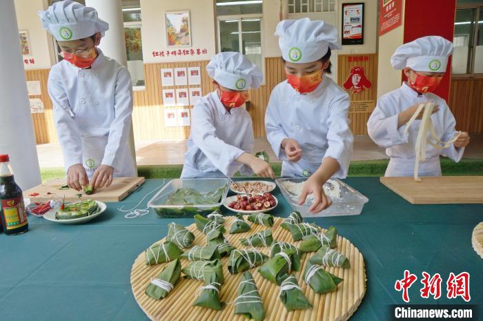 圖為鄭州小學(xué)生體驗包粽子。(資料圖) 韓章云 攝