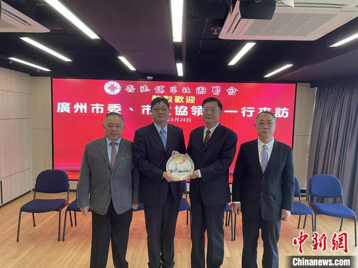 中共廣州市委常委、統(tǒng)戰(zhàn)部部長王世彤(右二)向香港僑界社團(tuán)聯(lián)會會長黃楚基(左二)致送紀(jì)念品?！∠愀蹆S界社團(tuán)聯(lián)會供圖