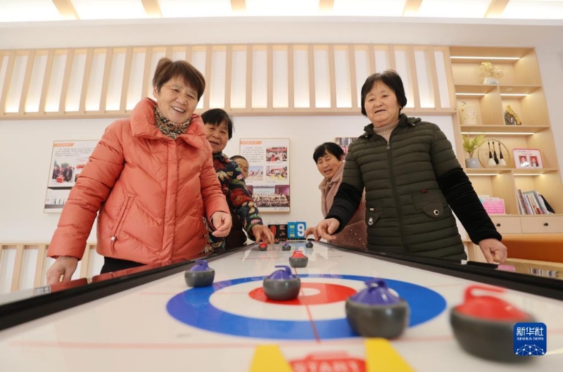 2月16日，在湖州市德清縣阜溪街道興山未來社區(qū)居家養(yǎng)老服務(wù)中心，社區(qū)老人在打“桌上冰壺球”。（圖源：新華社）