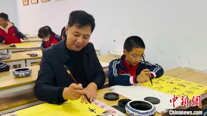 圖為“校長爺爺”同學(xué)生們一起練書法?！￡惙?攝