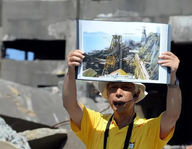 2015年8月8日，在日本長崎“軍艦島”，導(dǎo)游講解島上歷史。二戰(zhàn)期間，大量來自朝鮮半島和中國的勞工被強(qiáng)征到這座小島上勞動，受盡非人折磨甚至被虐致死。（圖源：新華社）