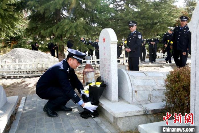 圖為西藏邊檢總站執(zhí)法調(diào)查支隊(duì)民警為旦增阿旺烈士擦拭墓碑、敬獻(xiàn)鮮花?！⒚麝?攝