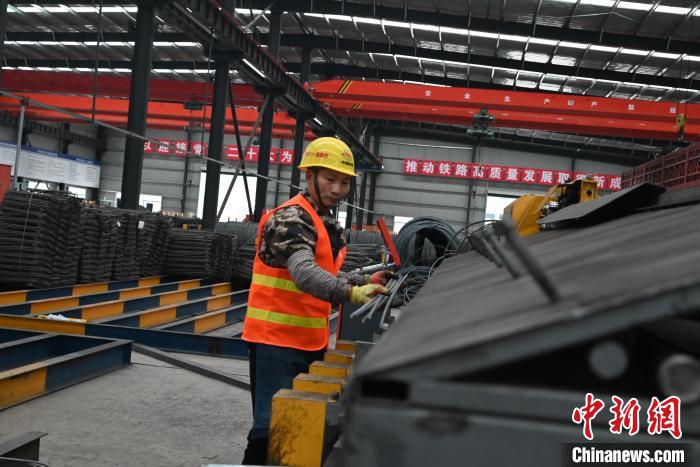 圖為工人正在操作鋼筋加工設(shè)備?！埿?攝