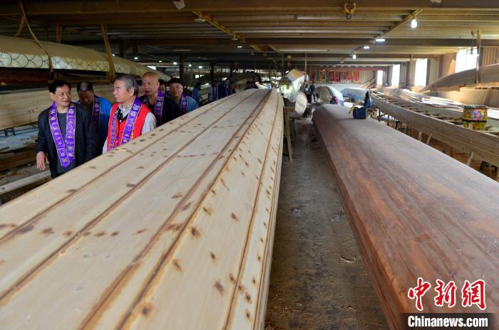 圖為“方莊龍舟制造技藝(閩侯縣)”傳承人方紹晃(左前)向參加儀式的兩岸嘉賓介紹龍舟制造技藝?！埍?攝