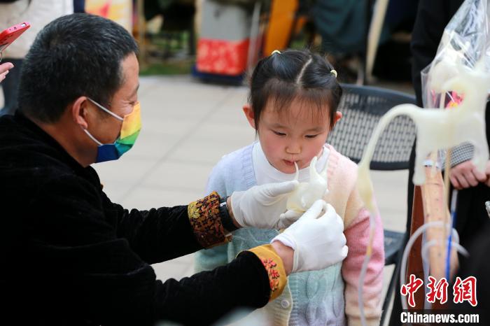 小朋友在春季黃河大集上體驗(yàn)吹糖人。　梁犇 攝