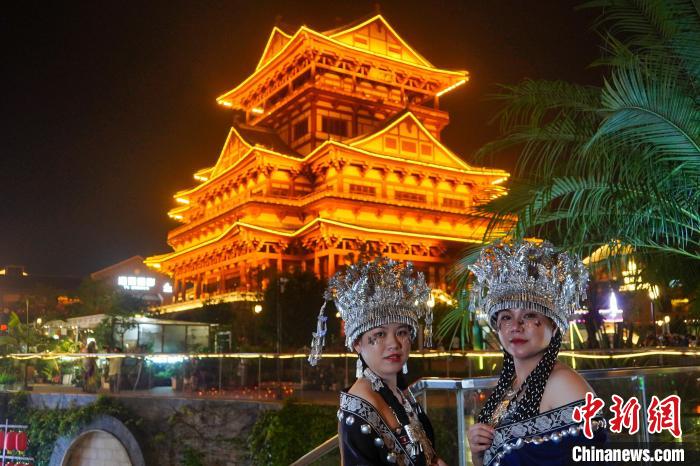 圖為身著苗族服飾的游客正在樓閣式建筑前“打卡”?！№f國政 攝