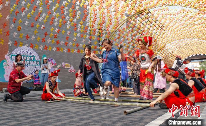 圖為臺(tái)胞在桂花公社歡度“三月三”，體驗(yàn)竹竿舞。　蔣豐慧 攝