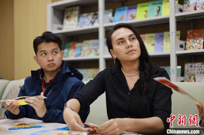 留學生們正在動手制作中國傳統(tǒng)玩具。　新蕾出版社供圖