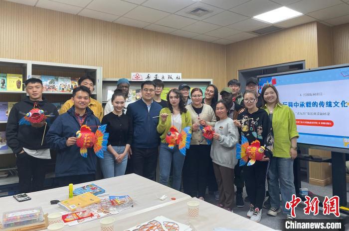 留學生們手持親手制作的中國傳統(tǒng)玩具合影留念?！⌒吕俪霭嫔绻﹫D