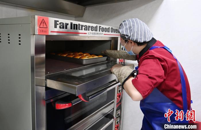 女性戒毒人員正在制作面包?！埇?攝