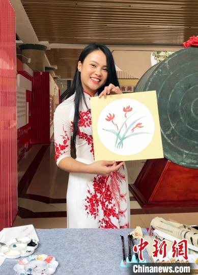 圖為越南留學(xué)生閉氏茹瓊在展示其畫作?！∨頃枣?攝