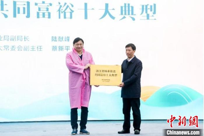 浙江省林業(yè)局副局長(zhǎng)陸獻(xiàn)峰(左)為浙江省林業(yè)推進(jìn)共同富裕十大典型授牌現(xiàn)場(chǎng)?！”P峰鄉(xiāng)人民政府 供圖