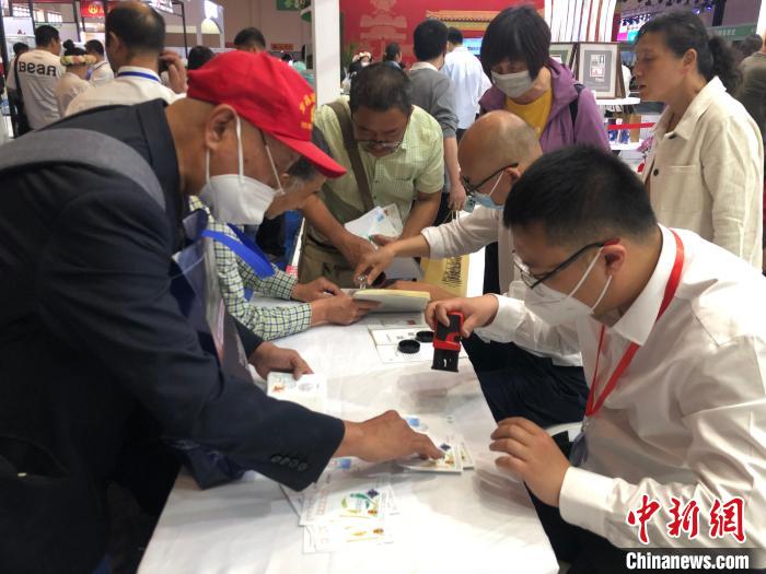 圖為集郵愛好者在現(xiàn)場加蓋郵戳。　葉娜 攝