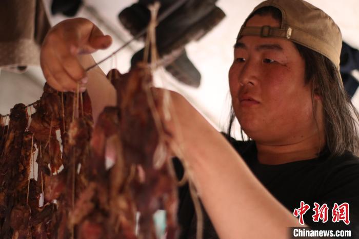 圖為達(dá)琳瑪在馴鹿點(diǎn)上的帳篷里晾肉干?！⊥踵嵷?攝