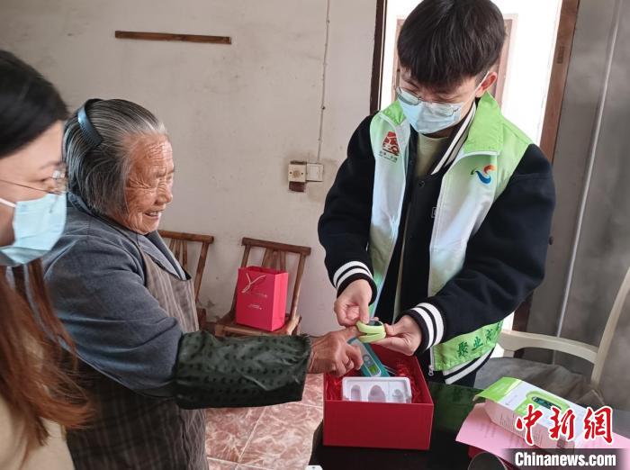 指導(dǎo)僑界老人使用血氧儀?！＄娦?攝