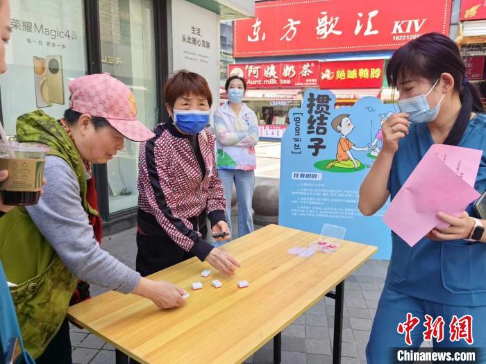 阿姨們熟練地玩起“摜結(jié)子”?！≠Z宇巍 攝