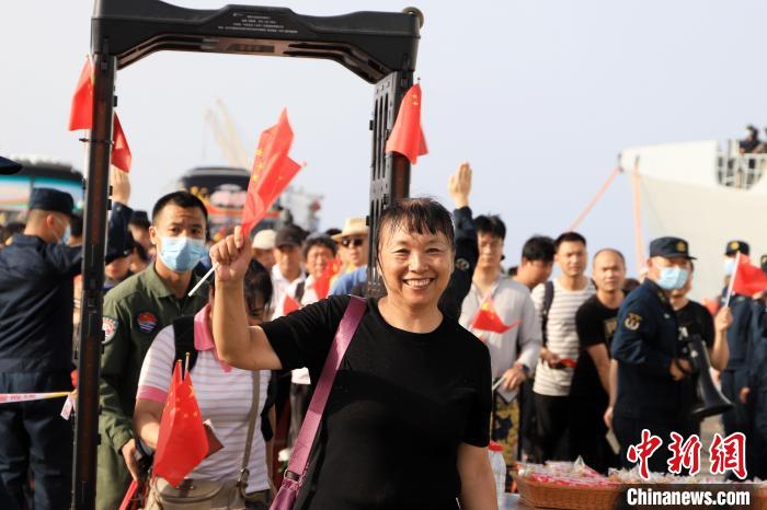 當?shù)貢r間4月26日，海軍軍艦赴蘇丹緊急撤離我在蘇丹人員。圖為撤離人員通過安檢后揮舞五星紅旗。　吳亢慈 攝