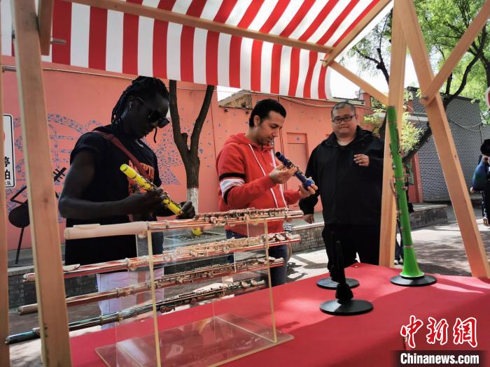 外籍友人在“樂(lè)器大集”上挑選樂(lè)器?！⊥貔i 攝