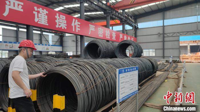 錢盛鵬正在物資堆放區(qū)檢查鋼筋質(zhì)量?！∴嚦?攝