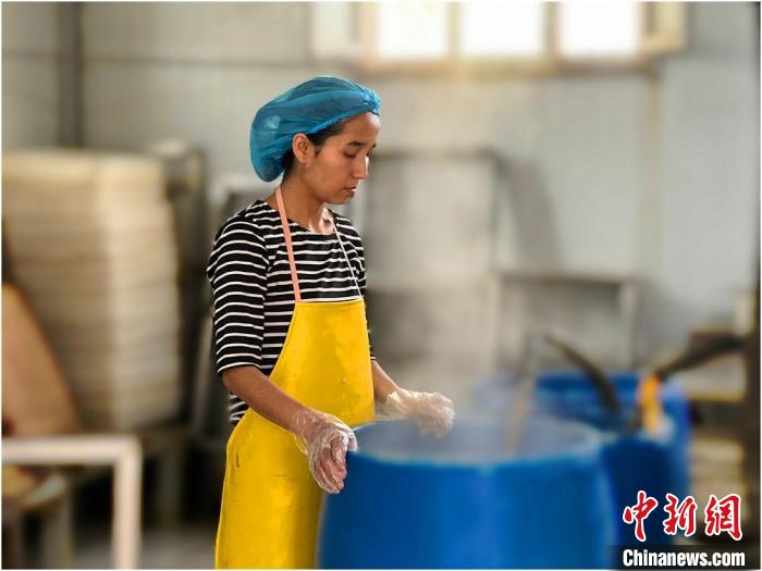 海日妮薩？麥麥提托合提在接煮好的豆?jié){。　李曉麗 攝