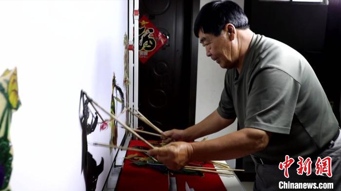 圖為馮克獻(xiàn)進(jìn)行皮影表演?！●R瑾 攝